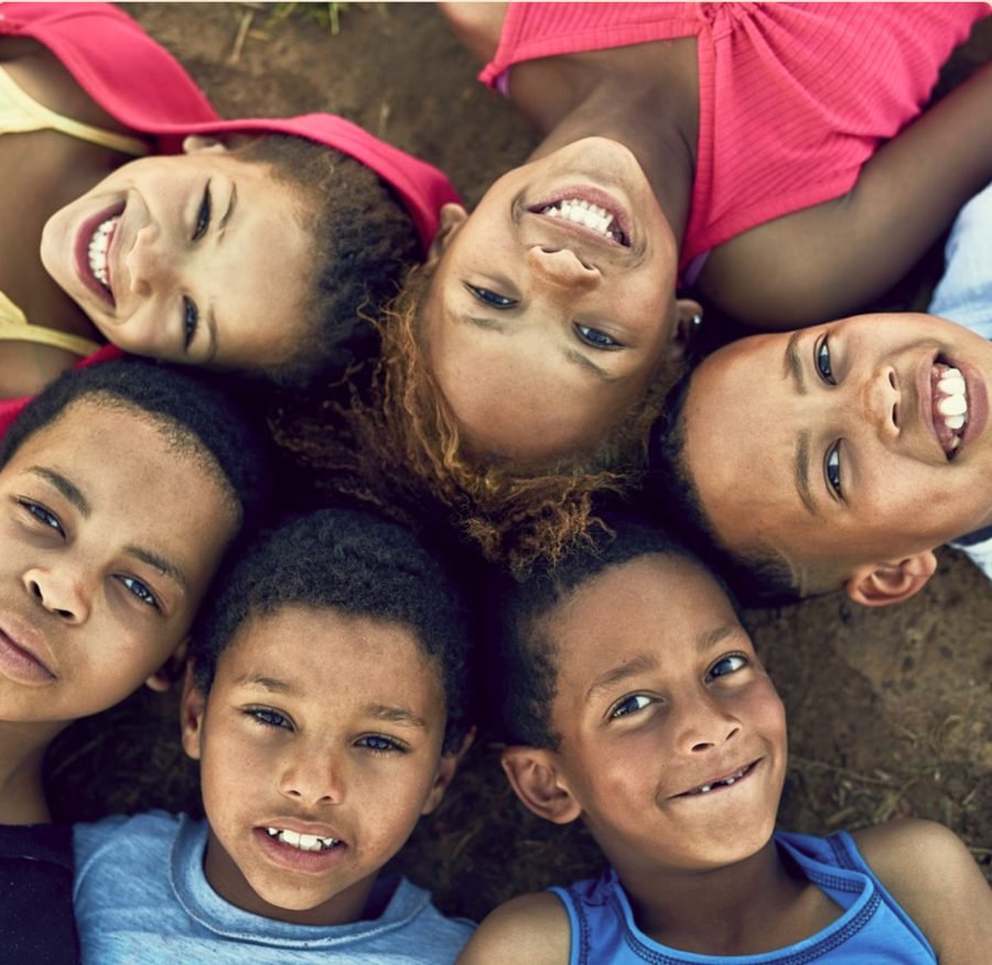 Crianças sorrindo deitadas em roda